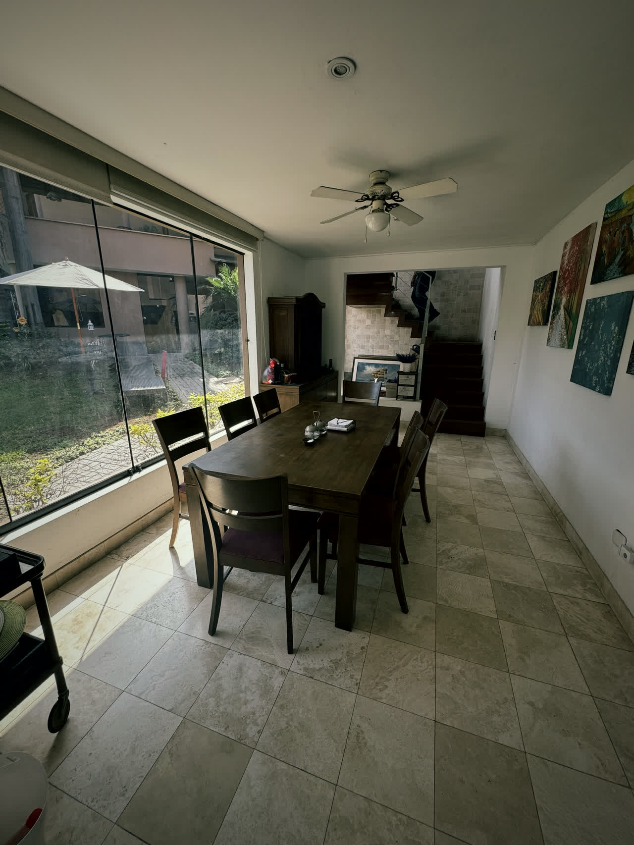 Comedor con ventanales de piso a techo hacia el jardín